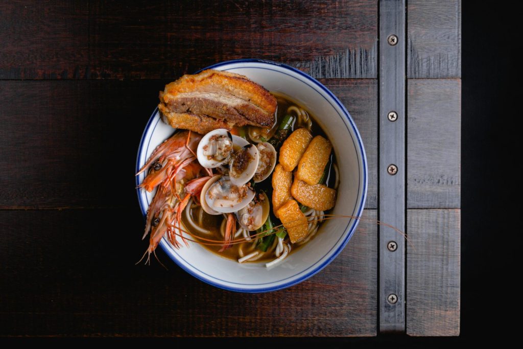 eine Schüssel Suppe mit Garnelen, Muscheln und Brot